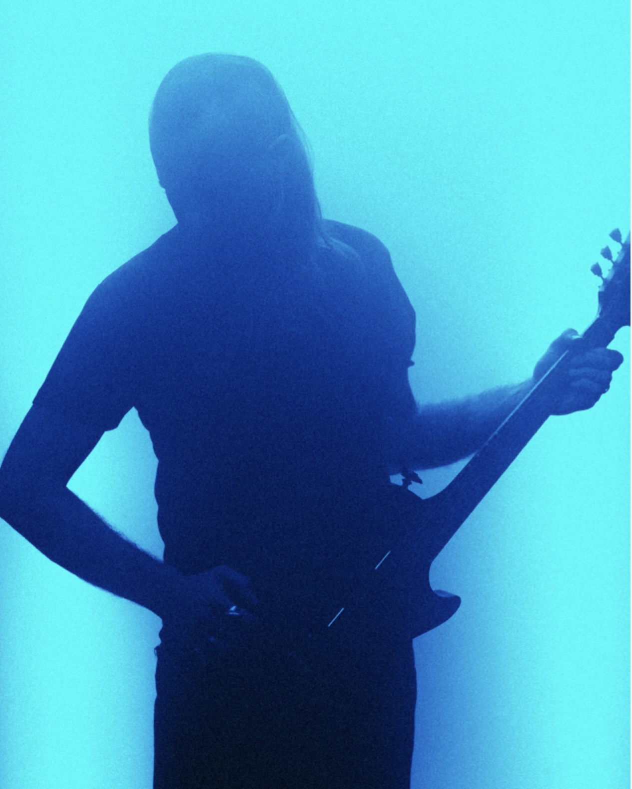 Blue-lit silhouette of Voidova performing with a guitar