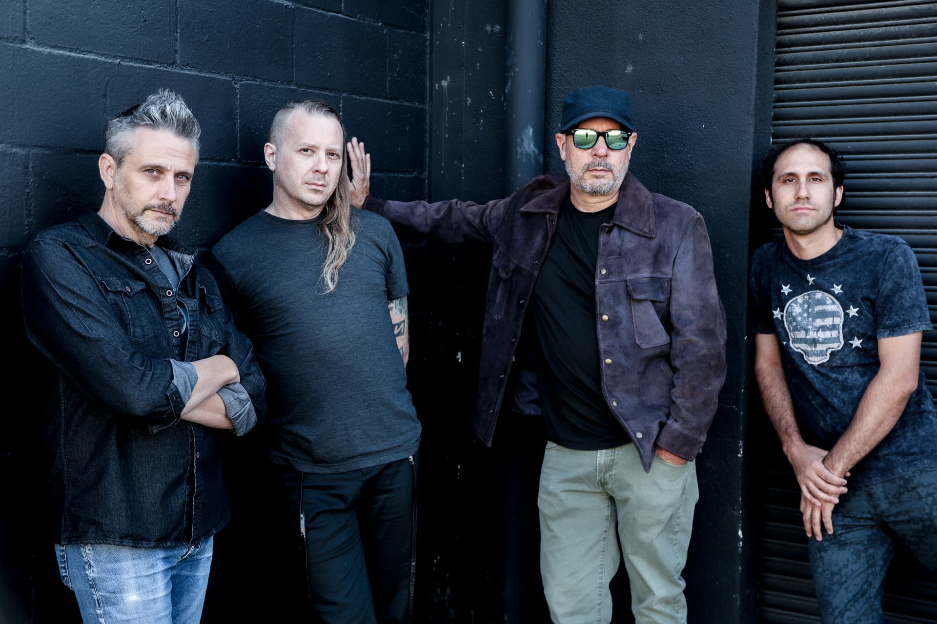 Voidova full band standing against a black brick wall