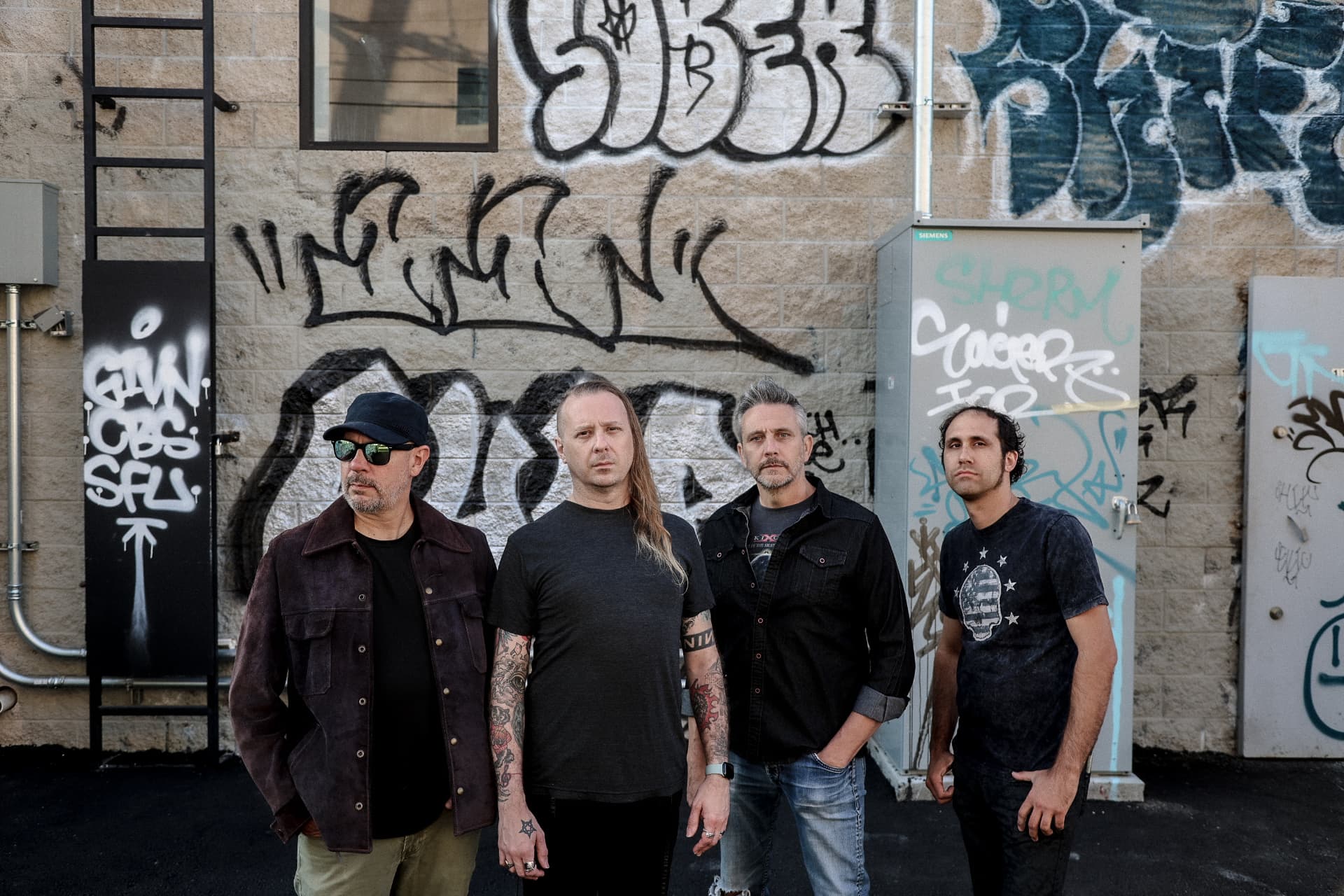 Voidova current live lineup — four band members standing in front of a graffiti-covered wall